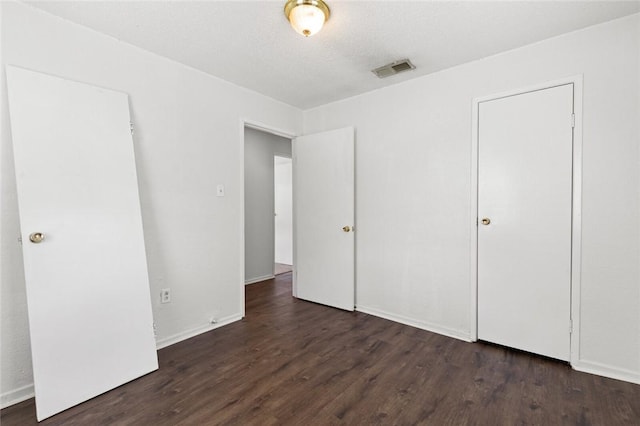 unfurnished bedroom featuring dark hardwood / wood-style flooring