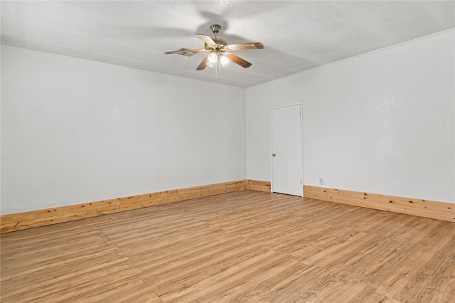 spare room with ceiling fan, light hardwood / wood-style flooring, and a textured ceiling