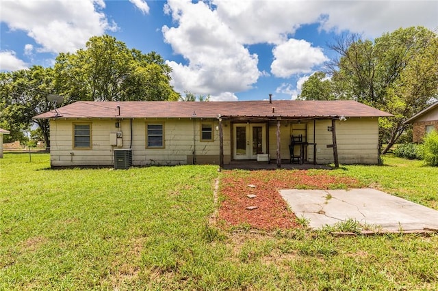 rear view of property with a lawn, a patio area, french doors, and central AC