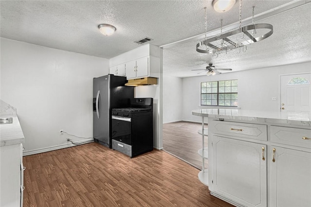 kitchen featuring white cabinets, stainless steel refrigerator with ice dispenser, gas stove, and light hardwood / wood-style floors