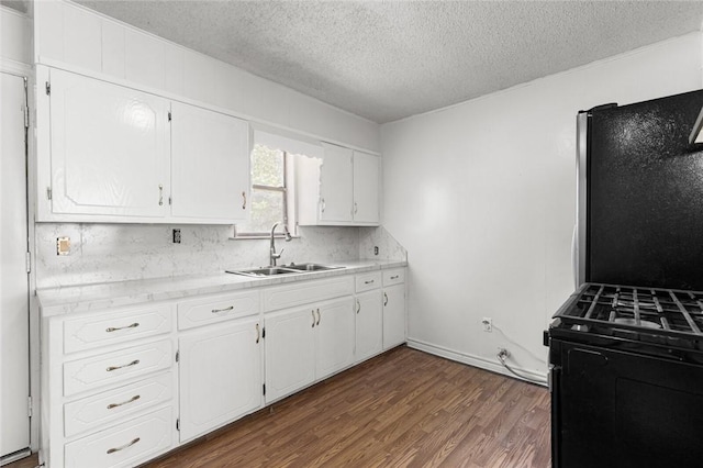 kitchen featuring black range oven, a textured ceiling, sink, hardwood / wood-style flooring, and white cabinetry