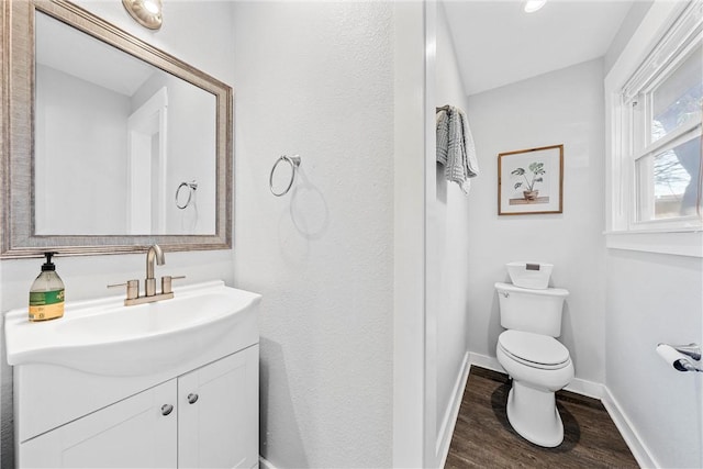 bathroom featuring vanity, wood-type flooring, and toilet