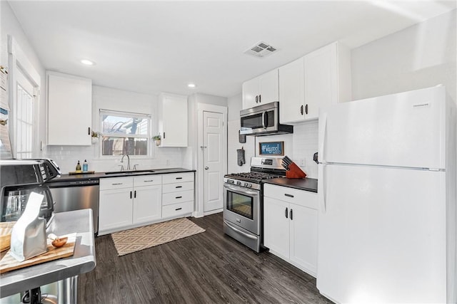 kitchen featuring sink, dark wood-type flooring, stainless steel appliances, and white cabinets