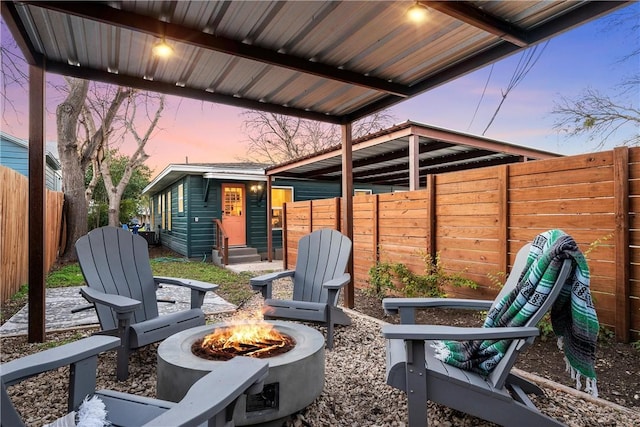 patio terrace at dusk featuring a fire pit