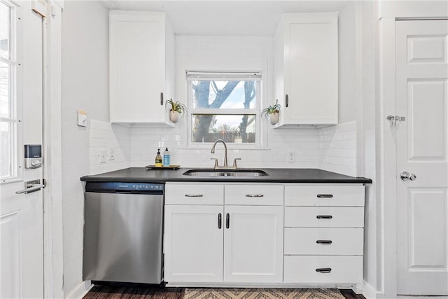 kitchen featuring stainless steel dishwasher, sink, decorative backsplash, and white cabinets