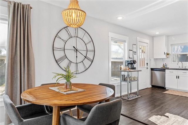 dining room with dark hardwood / wood-style floors, sink, and a notable chandelier