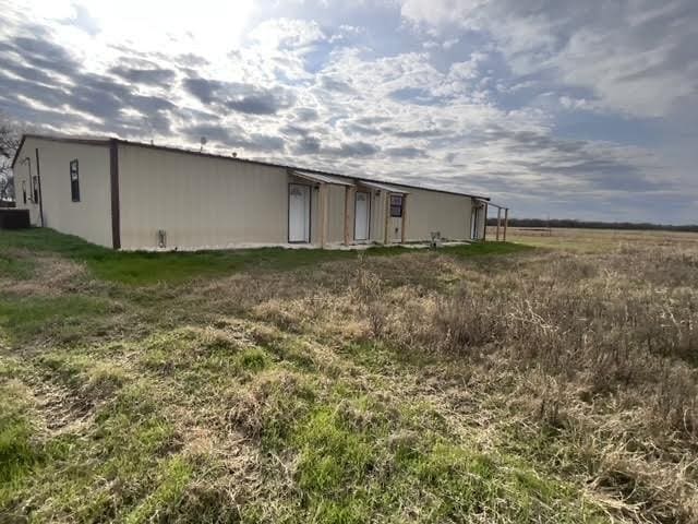 back of house with an outbuilding and a rural view