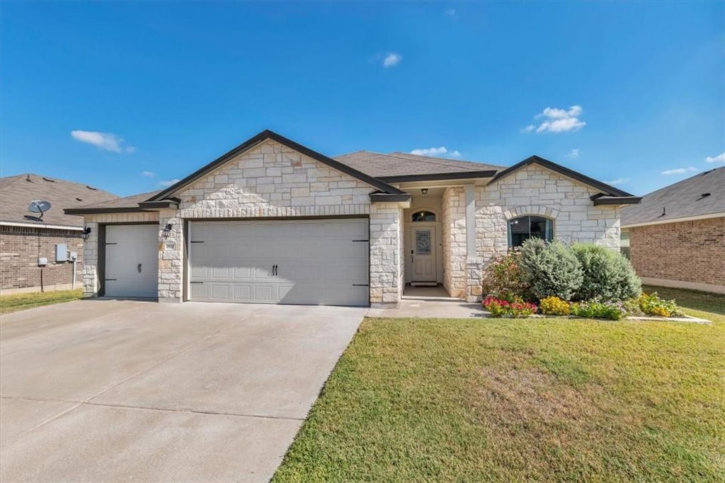 view of front of property featuring a front lawn and a garage