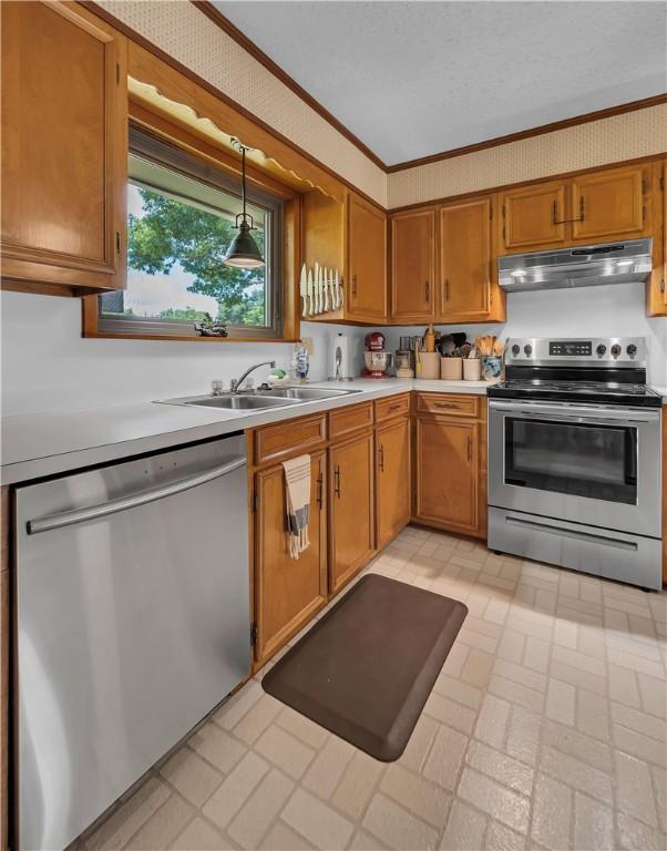 kitchen featuring a textured ceiling, stainless steel appliances, crown molding, sink, and decorative light fixtures