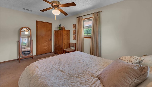 carpeted bedroom featuring multiple windows, a textured ceiling, and ceiling fan