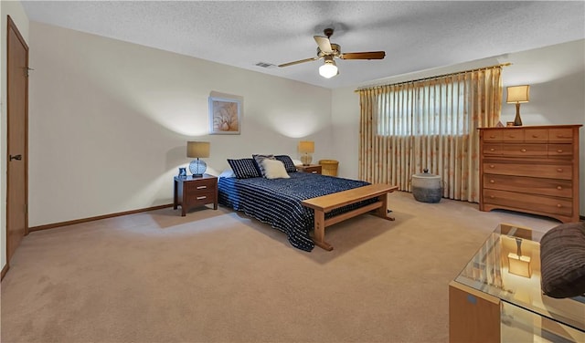 carpeted bedroom featuring ceiling fan and a textured ceiling