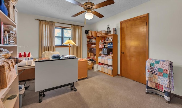 carpeted office space with a textured ceiling and ceiling fan