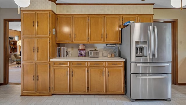 kitchen with ornamental molding and stainless steel refrigerator with ice dispenser