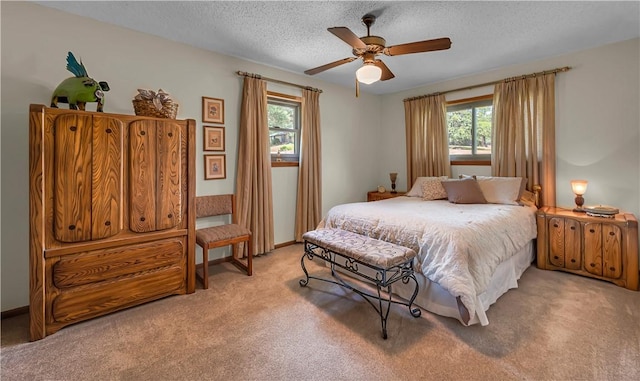 carpeted bedroom featuring ceiling fan, a textured ceiling, and multiple windows