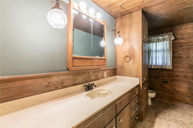 bathroom featuring wood ceiling, tile patterned flooring, wooden walls, vanity, and toilet