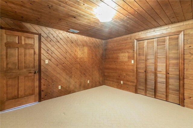 interior space featuring wooden ceiling, carpet floors, and wood walls