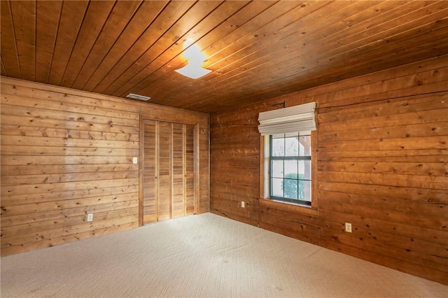 empty room featuring wood ceiling and wood walls