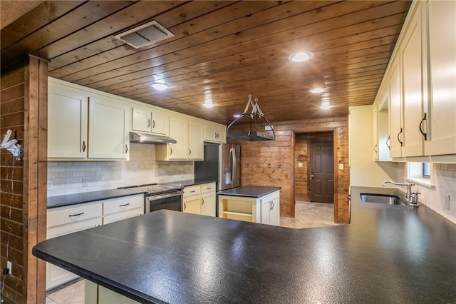 kitchen with stainless steel appliances, kitchen peninsula, sink, and backsplash