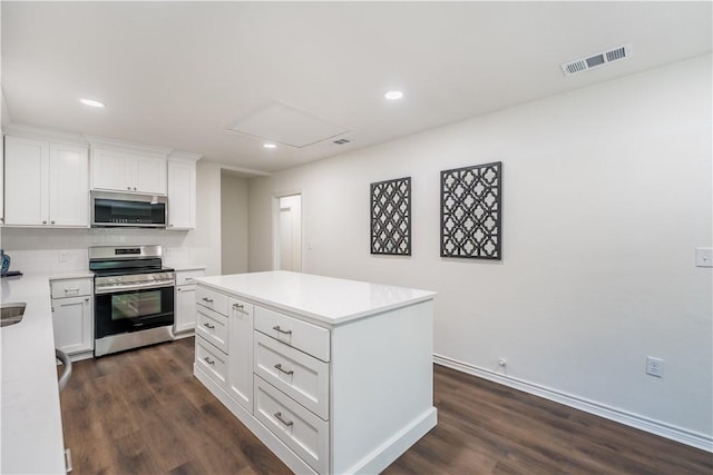 kitchen featuring appliances with stainless steel finishes, dark hardwood / wood-style floors, white cabinetry, and a kitchen island