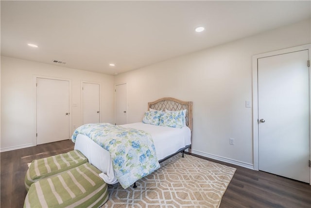 bedroom featuring dark hardwood / wood-style flooring and two closets