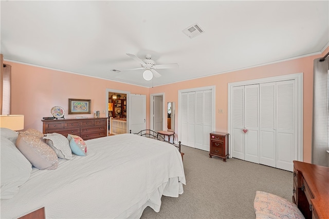 carpeted bedroom featuring two closets and ceiling fan