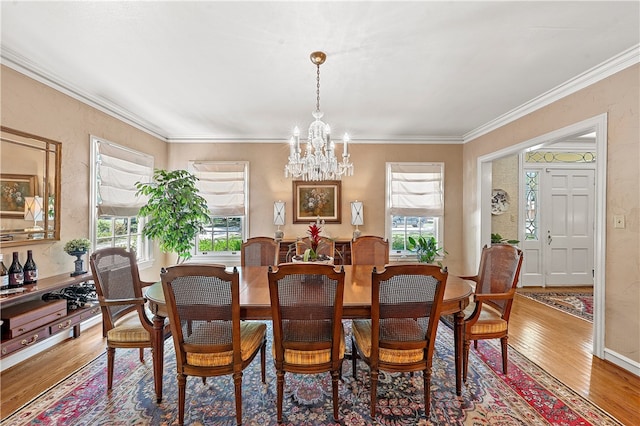 dining room with hardwood / wood-style floors, a chandelier, and ornamental molding