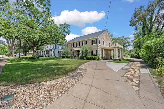 colonial-style house featuring a front yard