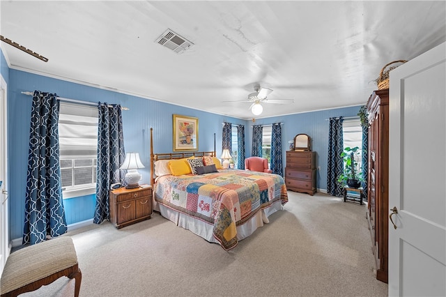 carpeted bedroom featuring ceiling fan and crown molding