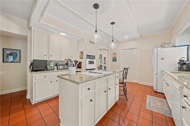 kitchen featuring pendant lighting, white appliances, white cabinets, light tile patterned floors, and a kitchen island