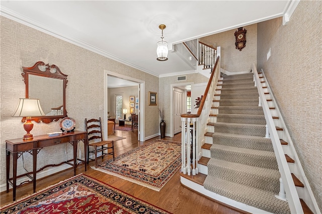 foyer entrance featuring dark hardwood / wood-style flooring and ornamental molding