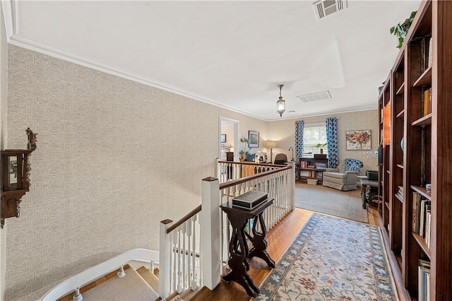 hallway with hardwood / wood-style floors and crown molding