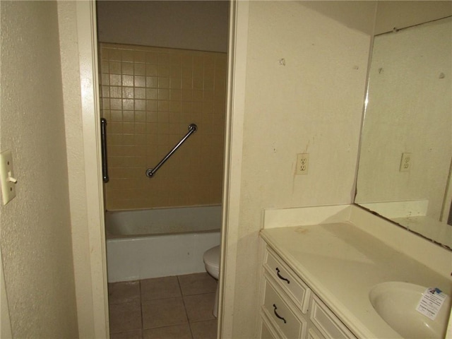 full bathroom featuring tile patterned flooring, vanity, toilet, and tiled shower / bath combo