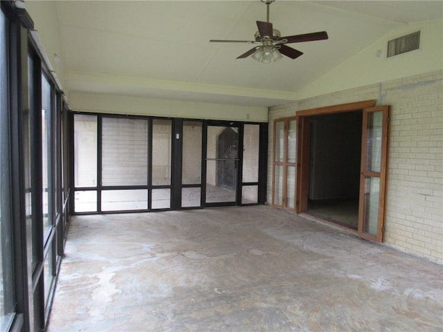 spare room with ceiling fan, concrete floors, brick wall, and vaulted ceiling