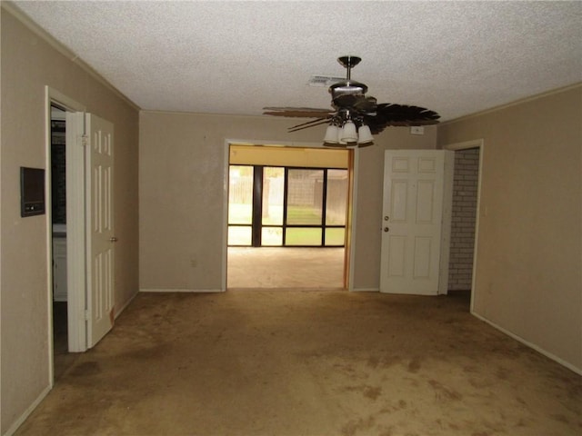 spare room featuring ceiling fan, light carpet, and a textured ceiling