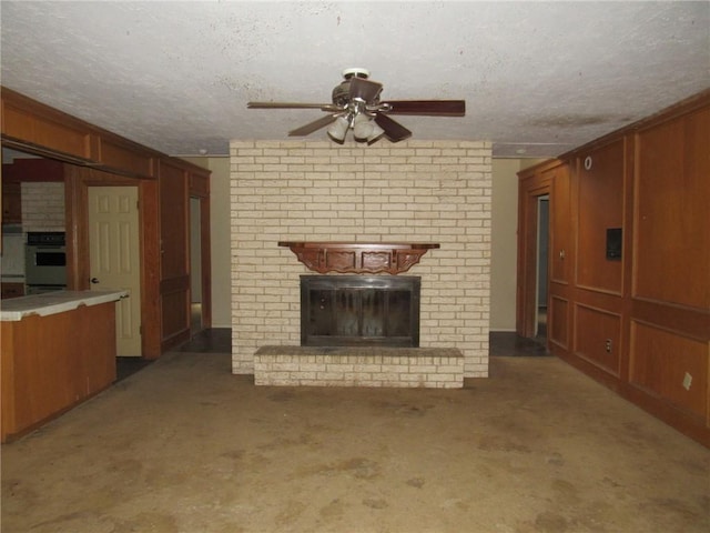 unfurnished living room featuring carpet, a fireplace, a textured ceiling, and wooden walls