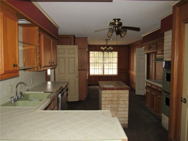 kitchen featuring sink, backsplash, kitchen peninsula, tile countertops, and ceiling fan with notable chandelier