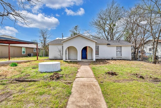 view of front of house featuring central air condition unit, stucco siding, a front yard, and fence