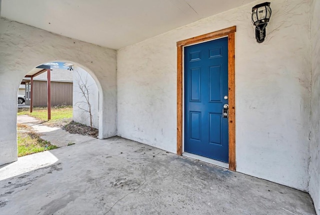 entrance to property featuring stucco siding