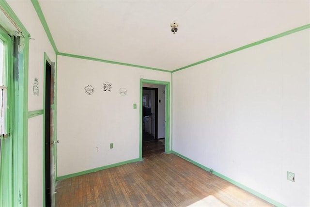 unfurnished room with ornamental molding and wood-type flooring