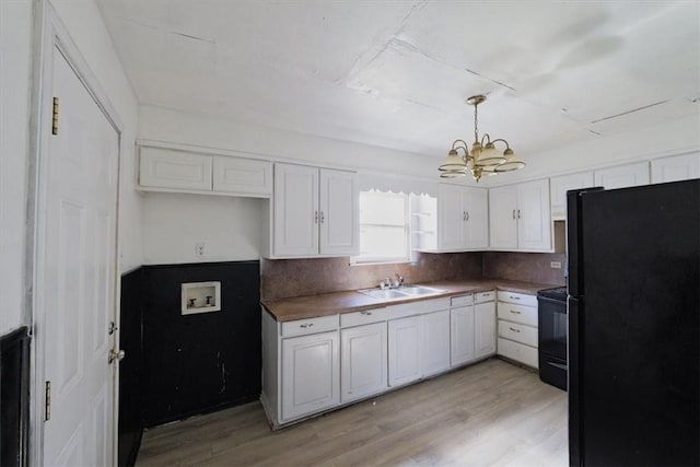 kitchen with decorative light fixtures, white cabinetry, sink, backsplash, and black appliances