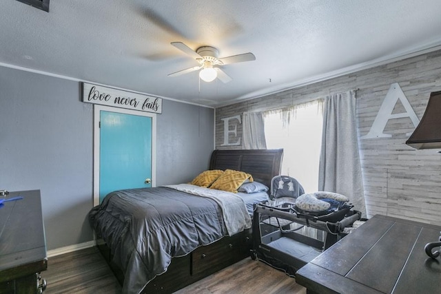 bedroom with ceiling fan, wooden walls, dark wood-type flooring, and a textured ceiling