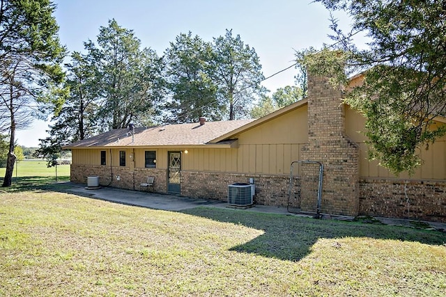 back of house featuring cooling unit, a yard, and a patio