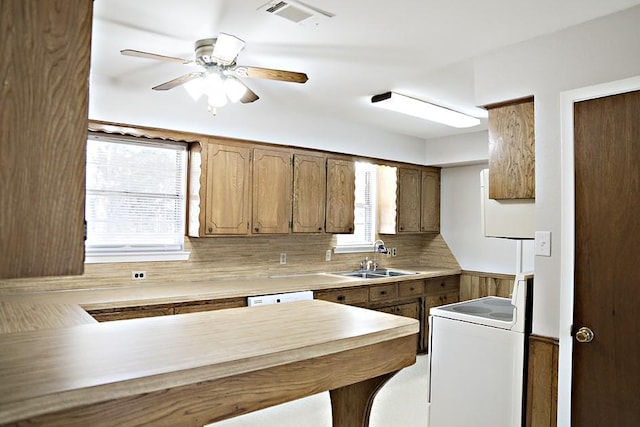 kitchen featuring white appliances, sink, decorative backsplash, ceiling fan, and kitchen peninsula