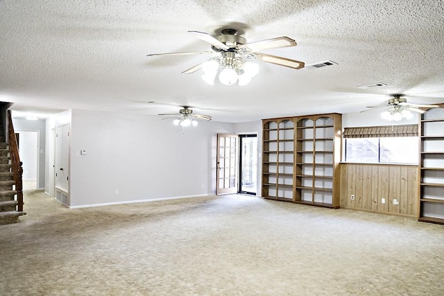 unfurnished living room featuring carpet flooring and a textured ceiling