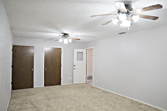 unfurnished room with carpet flooring and a textured ceiling