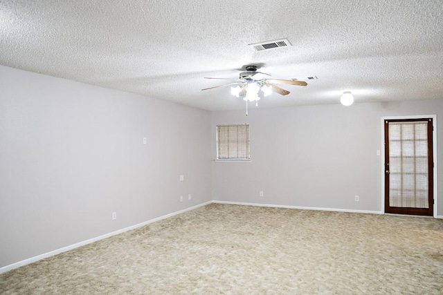 empty room with carpet, ceiling fan, and a textured ceiling