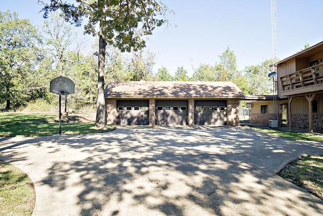 exterior space featuring a garage, an outdoor structure, and central AC