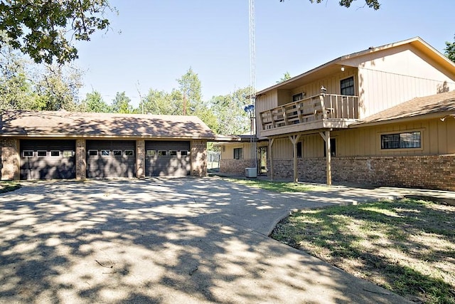 exterior space featuring a garage, a balcony, and an outbuilding