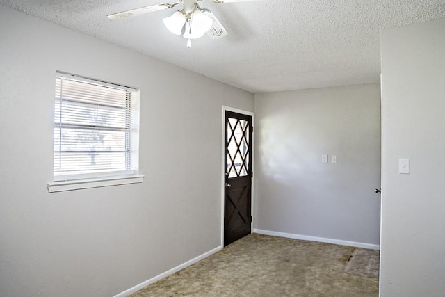 carpeted entrance foyer featuring a textured ceiling and ceiling fan