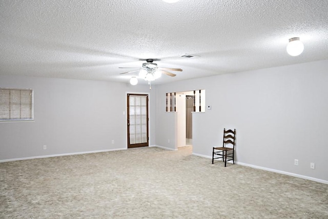 empty room featuring ceiling fan, carpet floors, and a textured ceiling